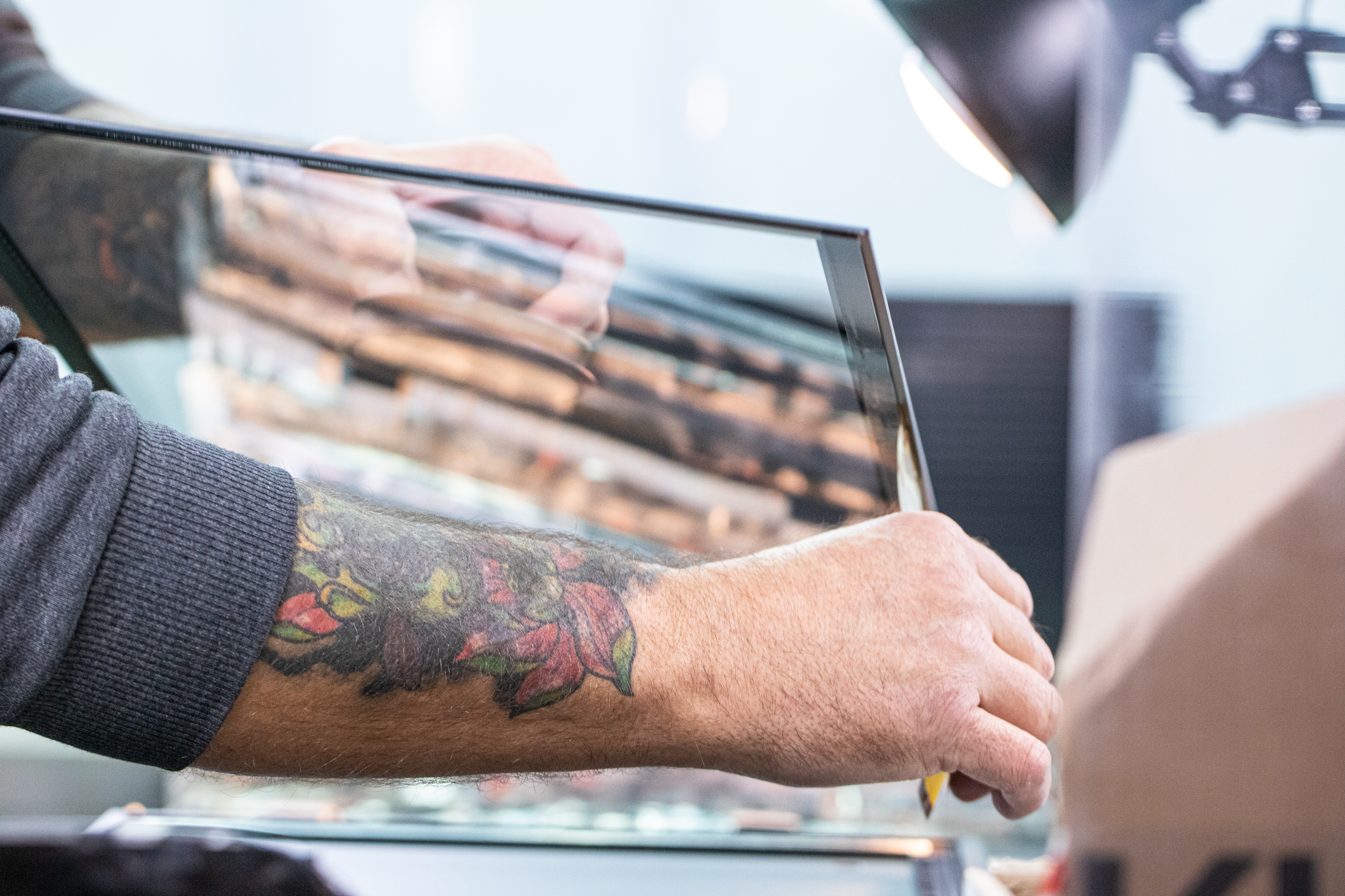 MIKKA Mitarbeiter verklebt sorgfältig und präzise die Glasscheibe im Assembling der Produktion | © MIKKA GmbH